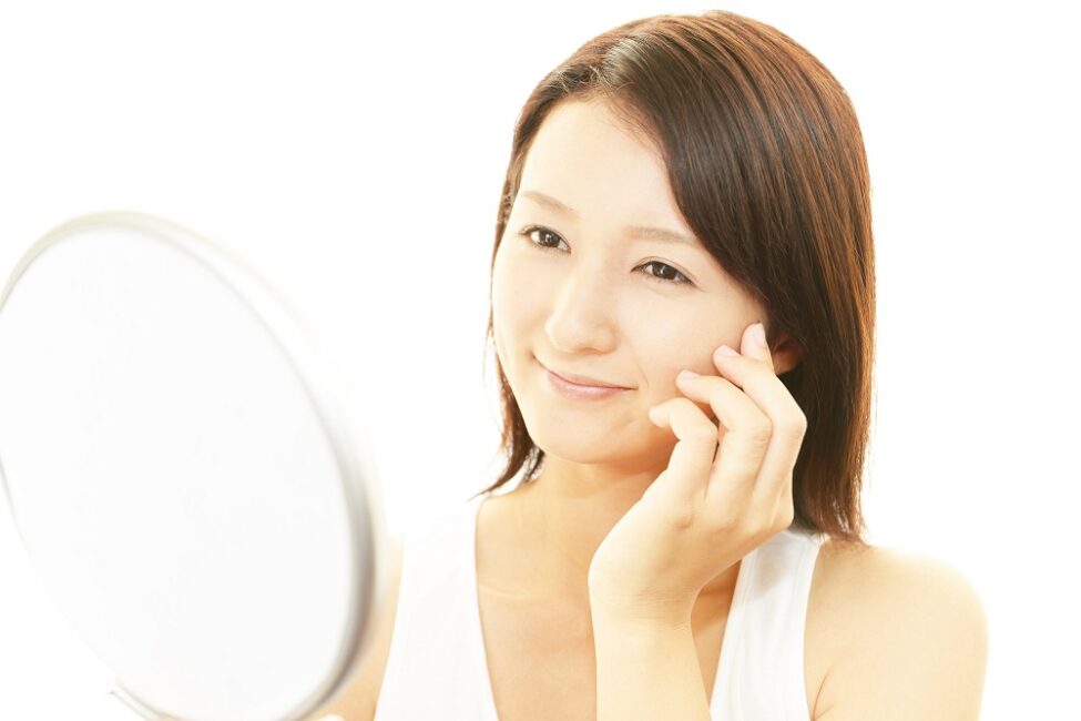 woman looking in mirror with waxed face